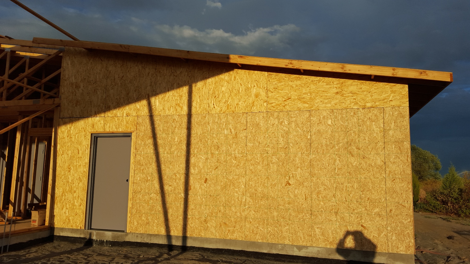 Sheathed exterior wall at golden hour with exterior door installed