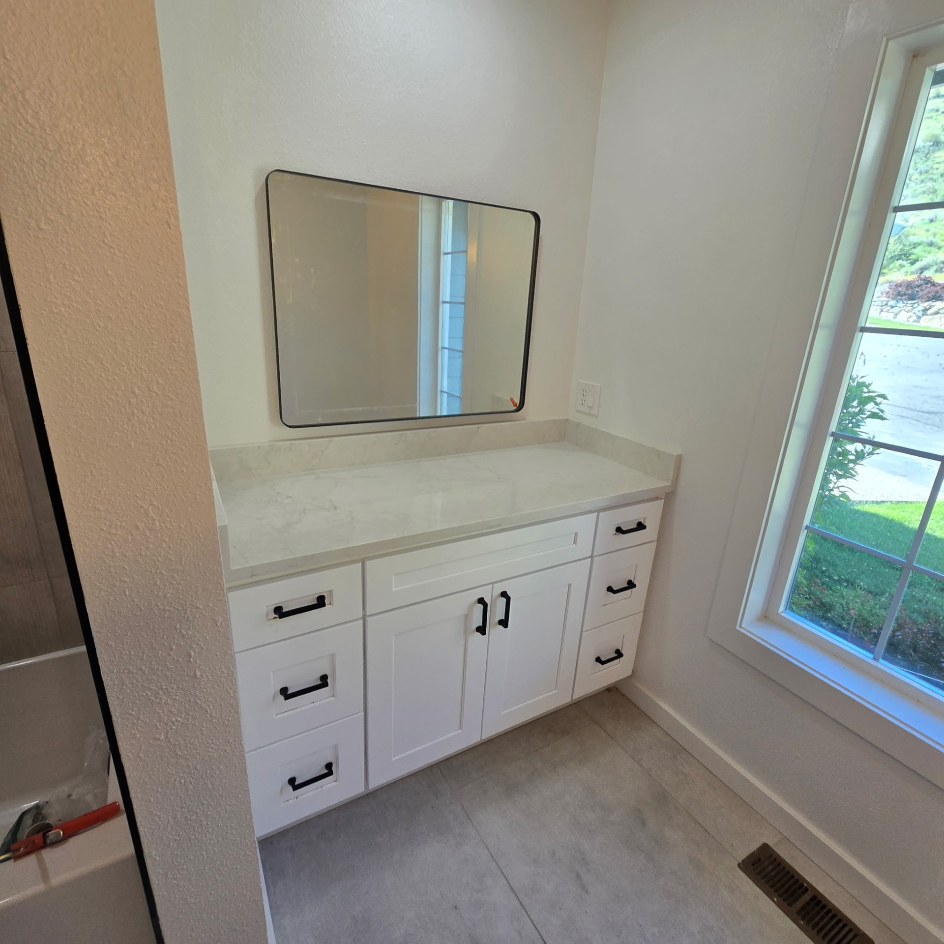 Chelan WA bathroom remodel — white shaker vanity with quartz countertop and matte black hardware