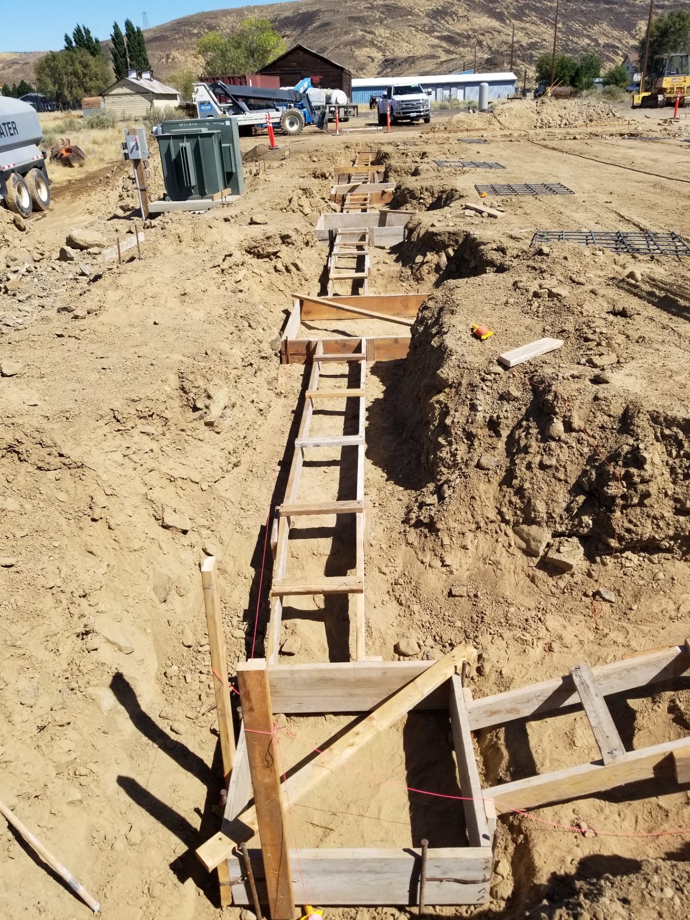 Footing forms staged down a trench line