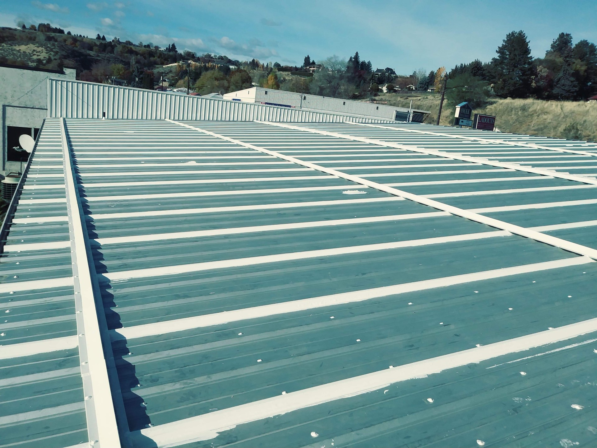 Roof coating grid pattern across a large commercial roof