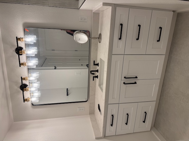 Bathroom remodel — long double vanity with Edison-style vanity lights and matte black hardware