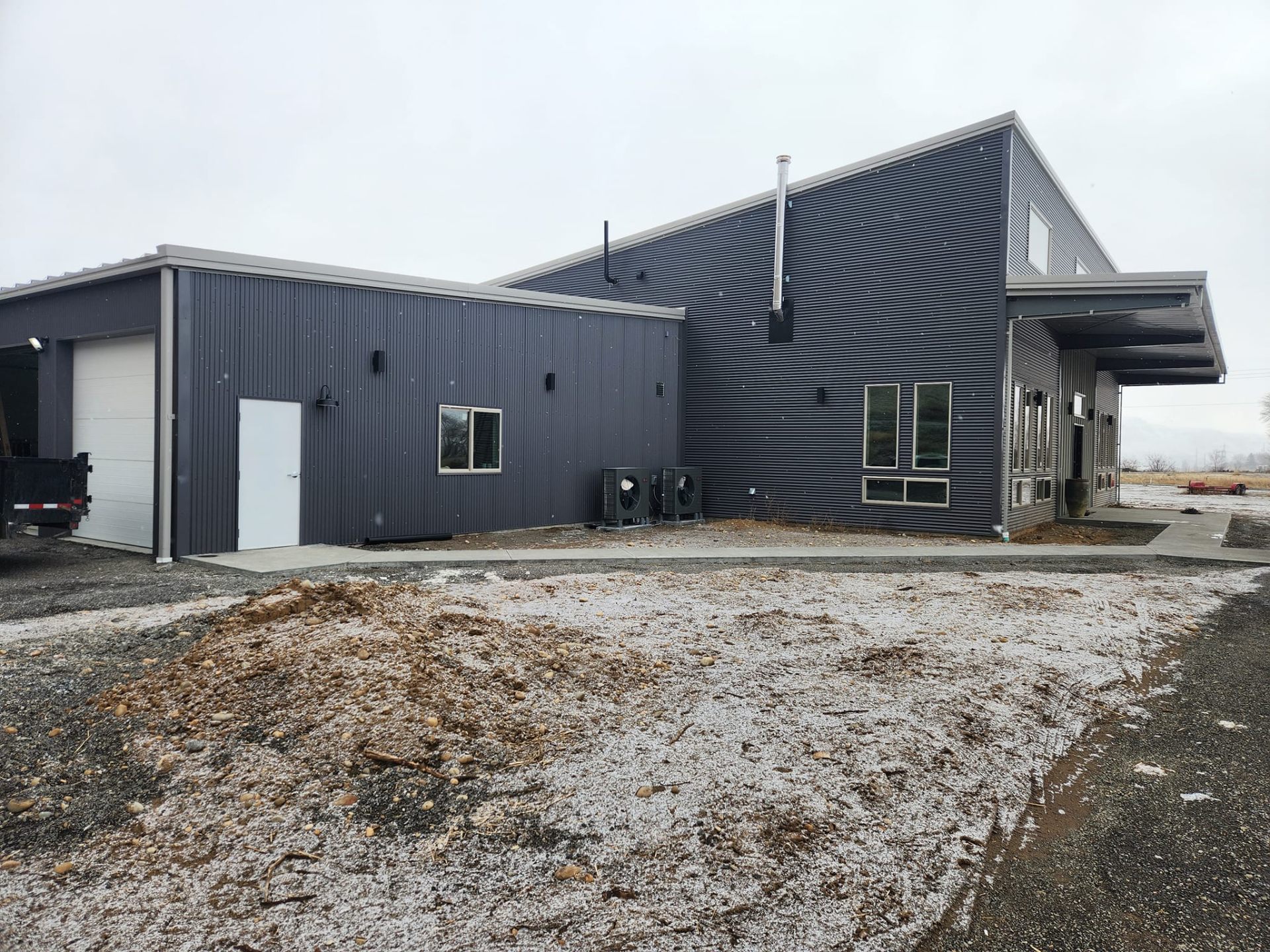 Custom home — finished steel building exterior with dark metal siding and covered entry