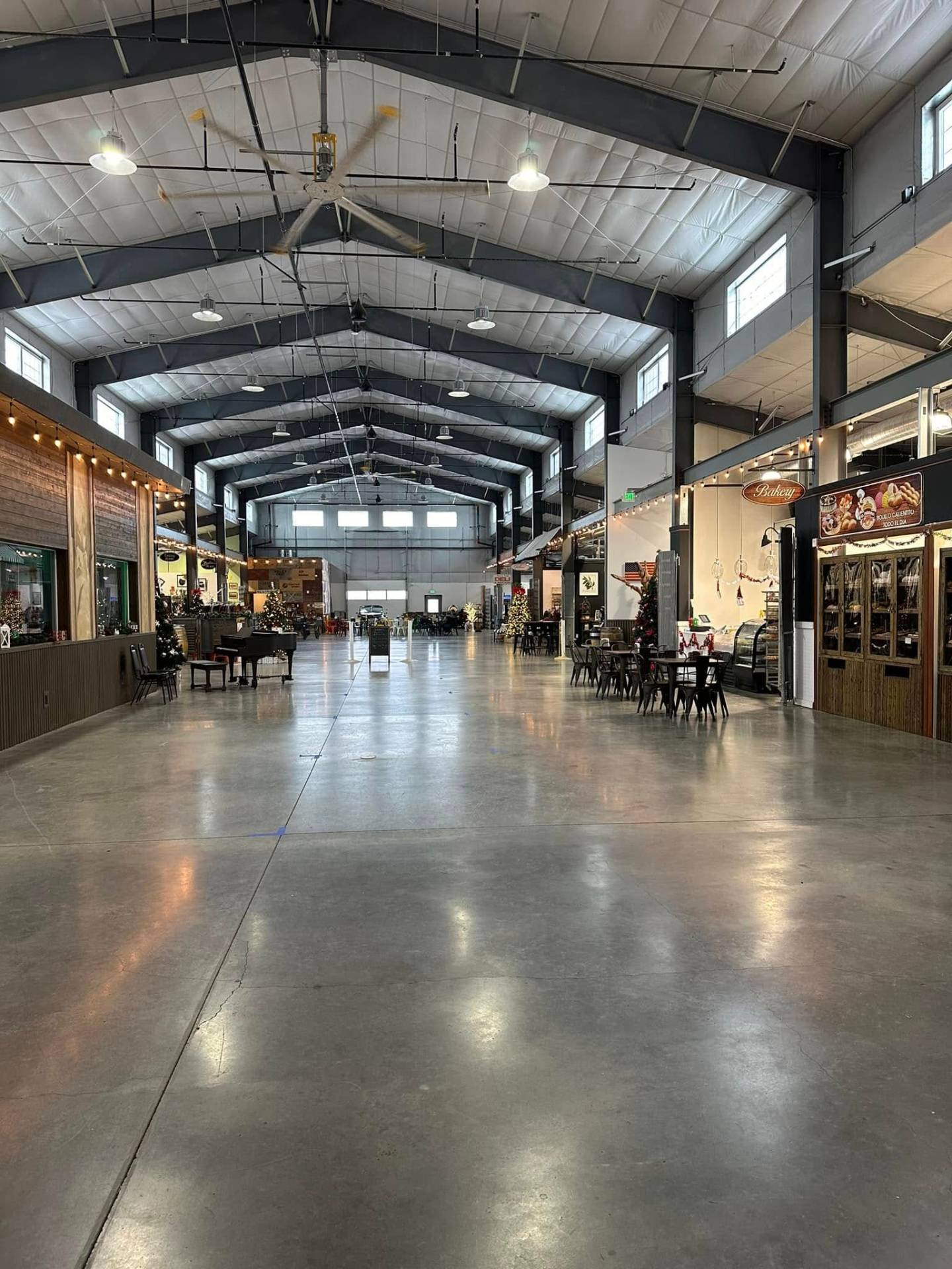 Quincy Public Market — wide center aisle with exposed steel framing and bakery storefront